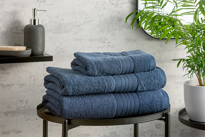 Blue folded towels on a black metal table in a bathroom