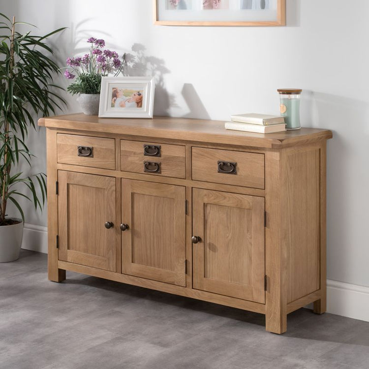 Wooden sideboard with three drawers and three doors, offering ample storage with decoration sitting on top