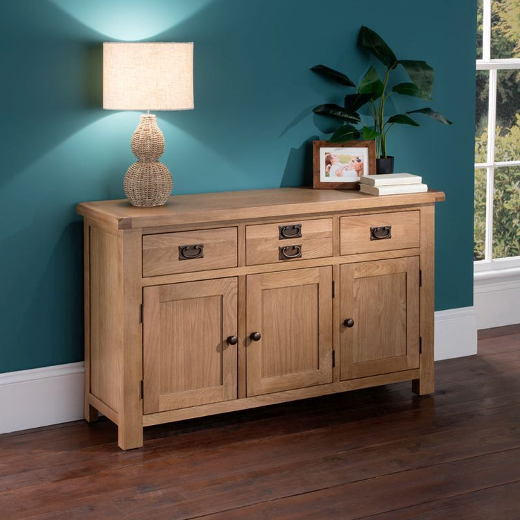 Wooden sideboard three drawer and three door, with a lamp and plant placed on top