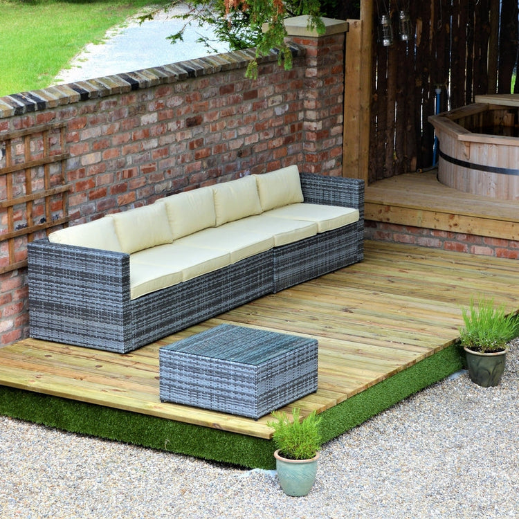 A stylish rattan and cream sofa set arranged on a wooden decking outside 