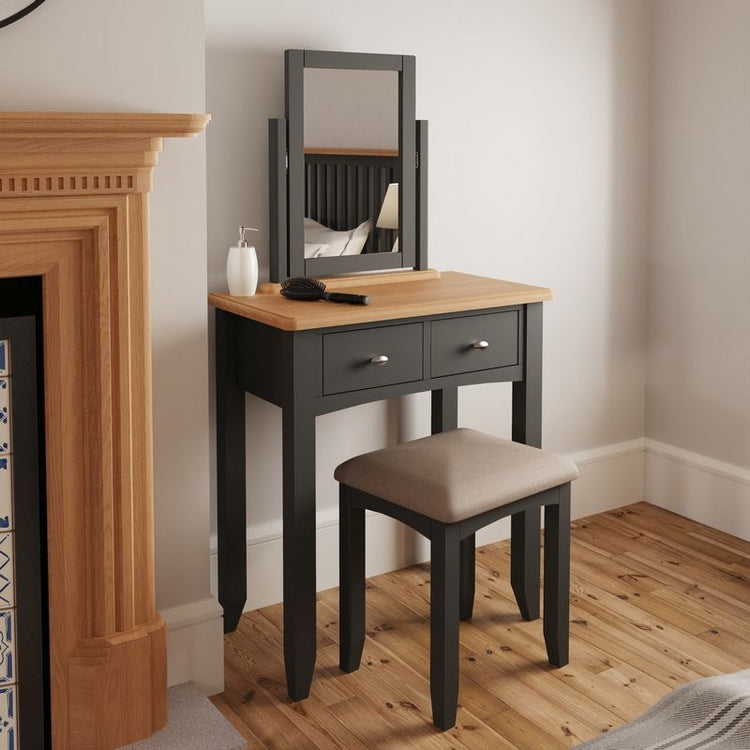 A vanity desk crafted from oak wood, featuring a large mirror, drawers for storage, and a matching upholstered stool, adding a touch of elegance to the bedroom or dressing area