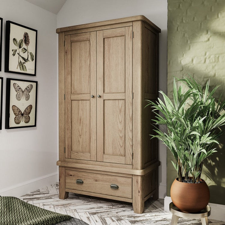 Spacious oak wardrobe with one drawer compartment and a classic design in a green coloured room