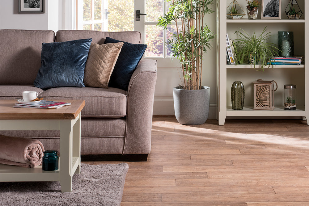 A living room with neatly arranged furniture, featuring a comfortable sofa, armchairs, coffee table, and decorative accents