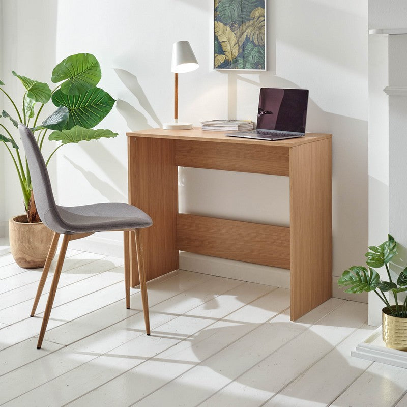 A wooden desk featuring ample workspace and drawers for organisation, positioned in a well-lit room