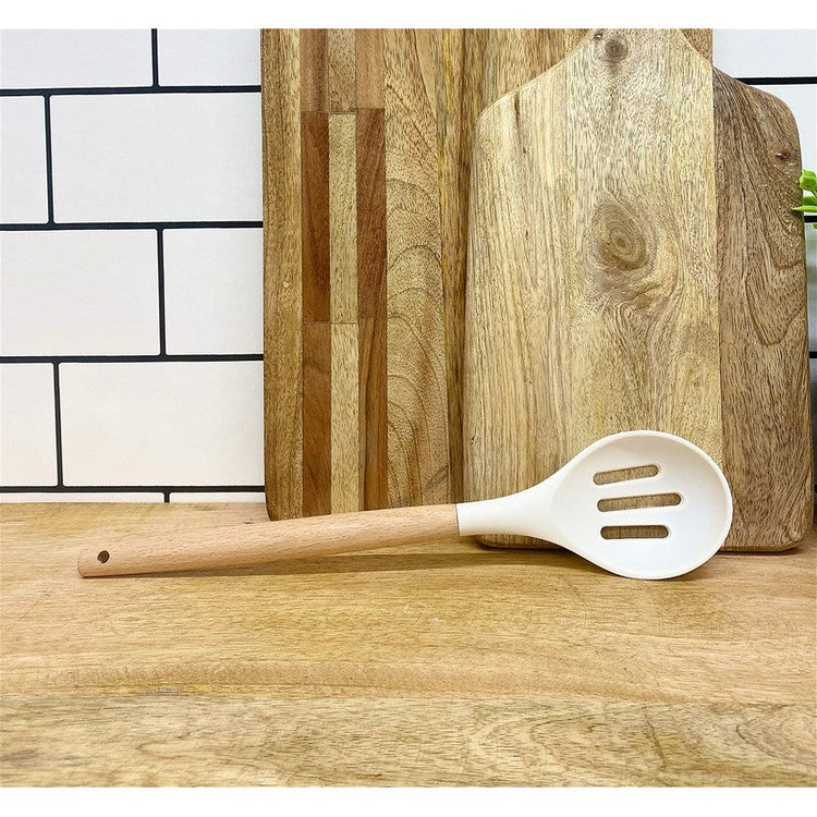 Wooden kitchen spoon beside wooden chopping boards