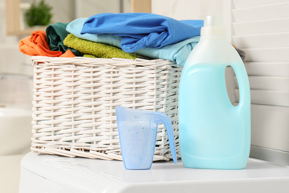 Cleaning products next to a basket of laundry