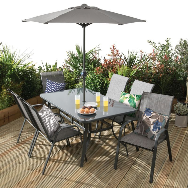 A glass table garden dining set with a parasol, arranged on a wooden decking