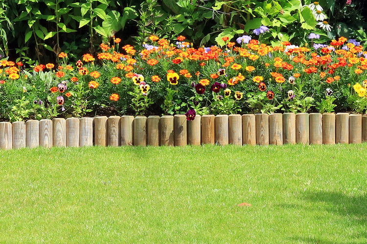 Wooden garden edging bordering a vibrant green lawn, adorned with lush plants and flowers