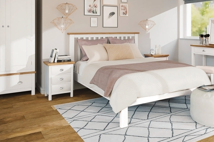 Double bed with neutral bedding in a bedroom adorned with soft tones, complemented by a white rug