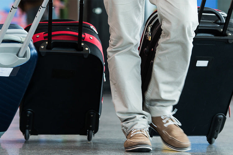 A man standing with luggage, ready for travel