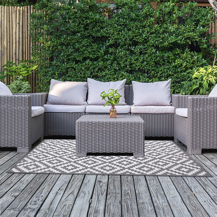 Garden patio rug next to rattan garden sofa set on a decking