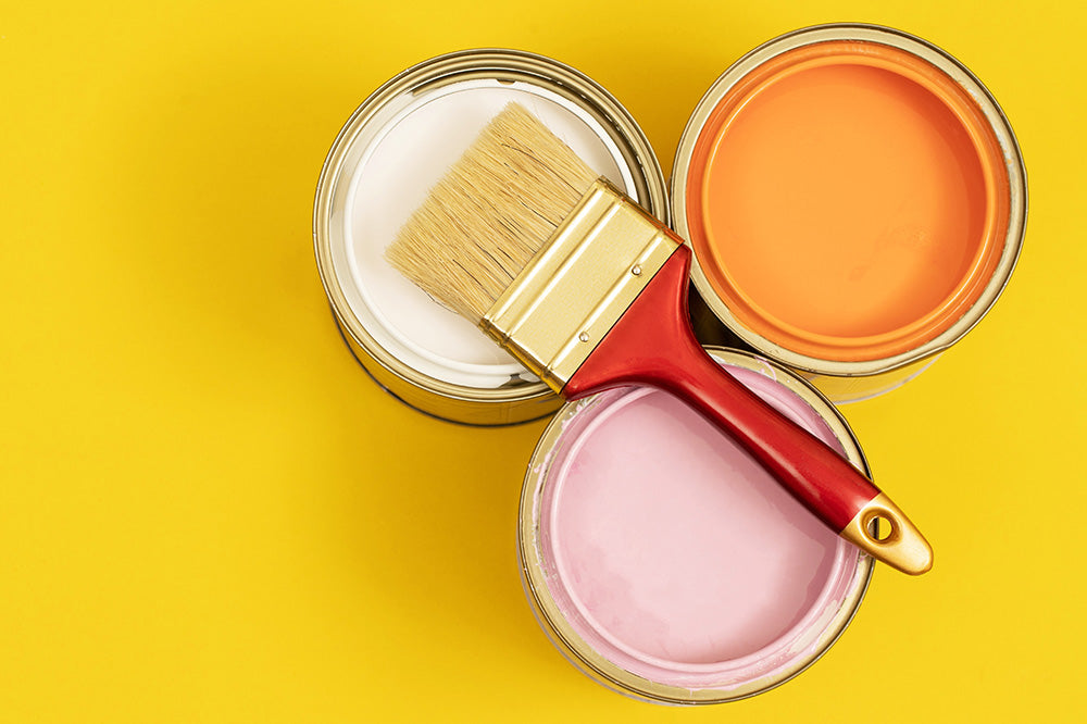 Orange, white and pink paint with a paintbrush