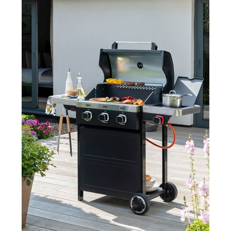 Gas BBQ grill with wheels, sizzling and grilling food outdoors